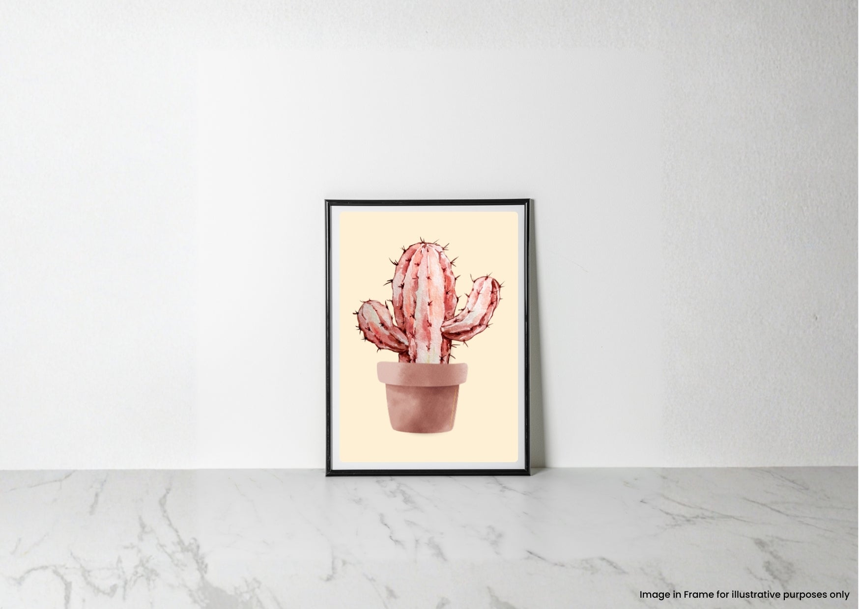 A framed art print featuring a watercolor-style pink cactus in a terracotta pot, leaning against a white wall on a light marble surface.