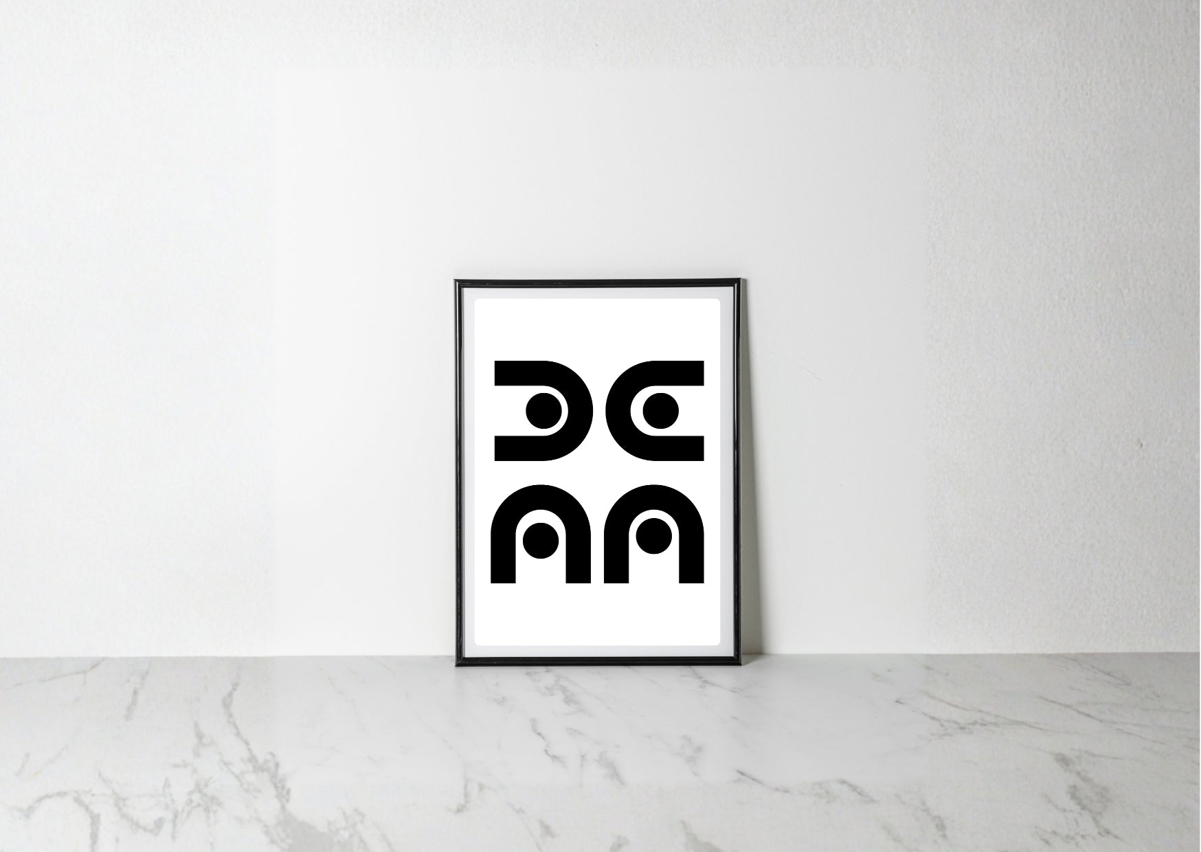 A minimalist black and white art print with a thin black frame, leaning against a white wall on a light gray marble surface.
