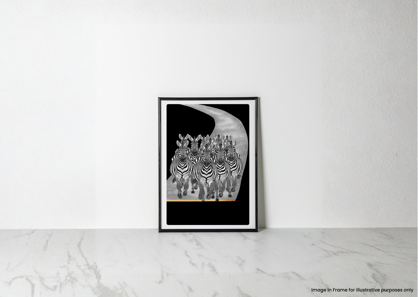 A framed black and white art print of zebras on a curved road, leaning against a white wall on a light marble surface.