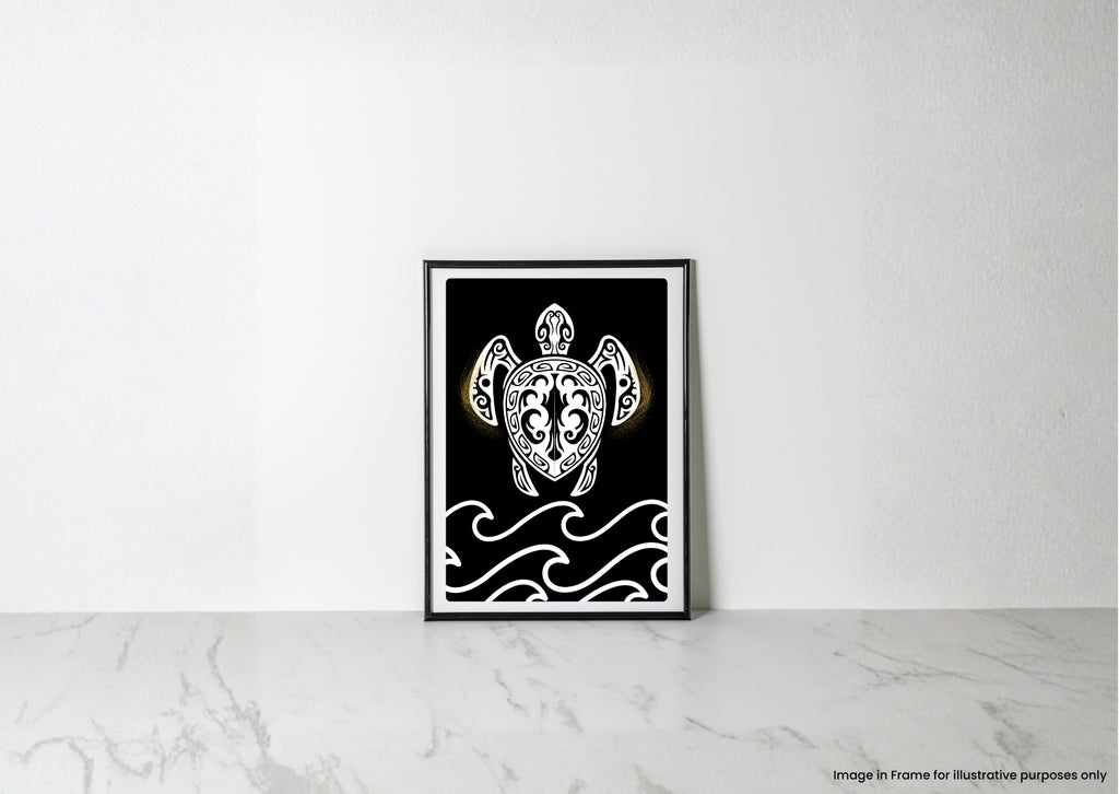 A framed black and white art print featuring a Polynesian-style turtle illustration with gold accents, leaning against a white wall on a light marble surface.