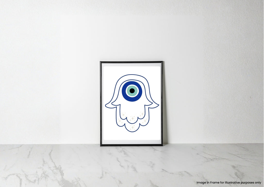 A framed art print featuring a white hamsa hand outline with a blue and green evil eye design, leaning against a white wall on a light marble surface.