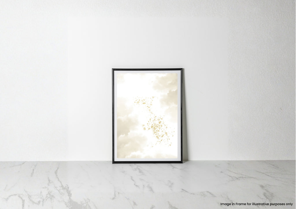 A vertical black-framed art print leaning against a white textured wall on a light marble surface. The print features an abstract design of cream, beige, and soft gold cloud-like forms.