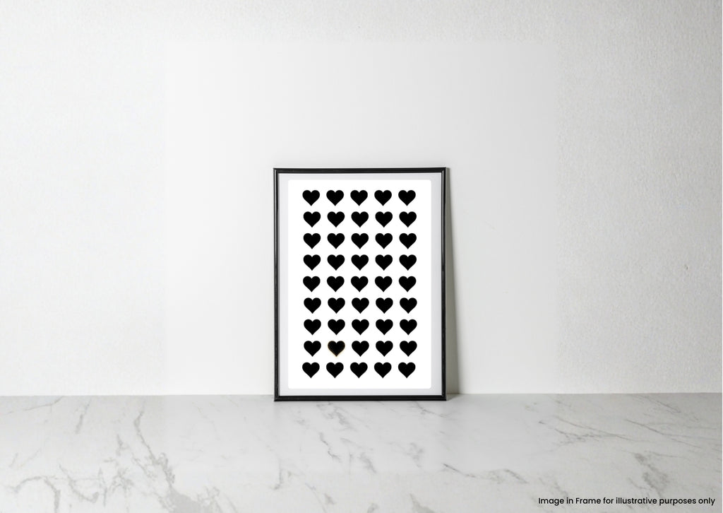 A minimalist black and white art print featuring a grid of small black hearts on a white background, displayed in a thin black frame leaning against a white wall on a light marble surface.