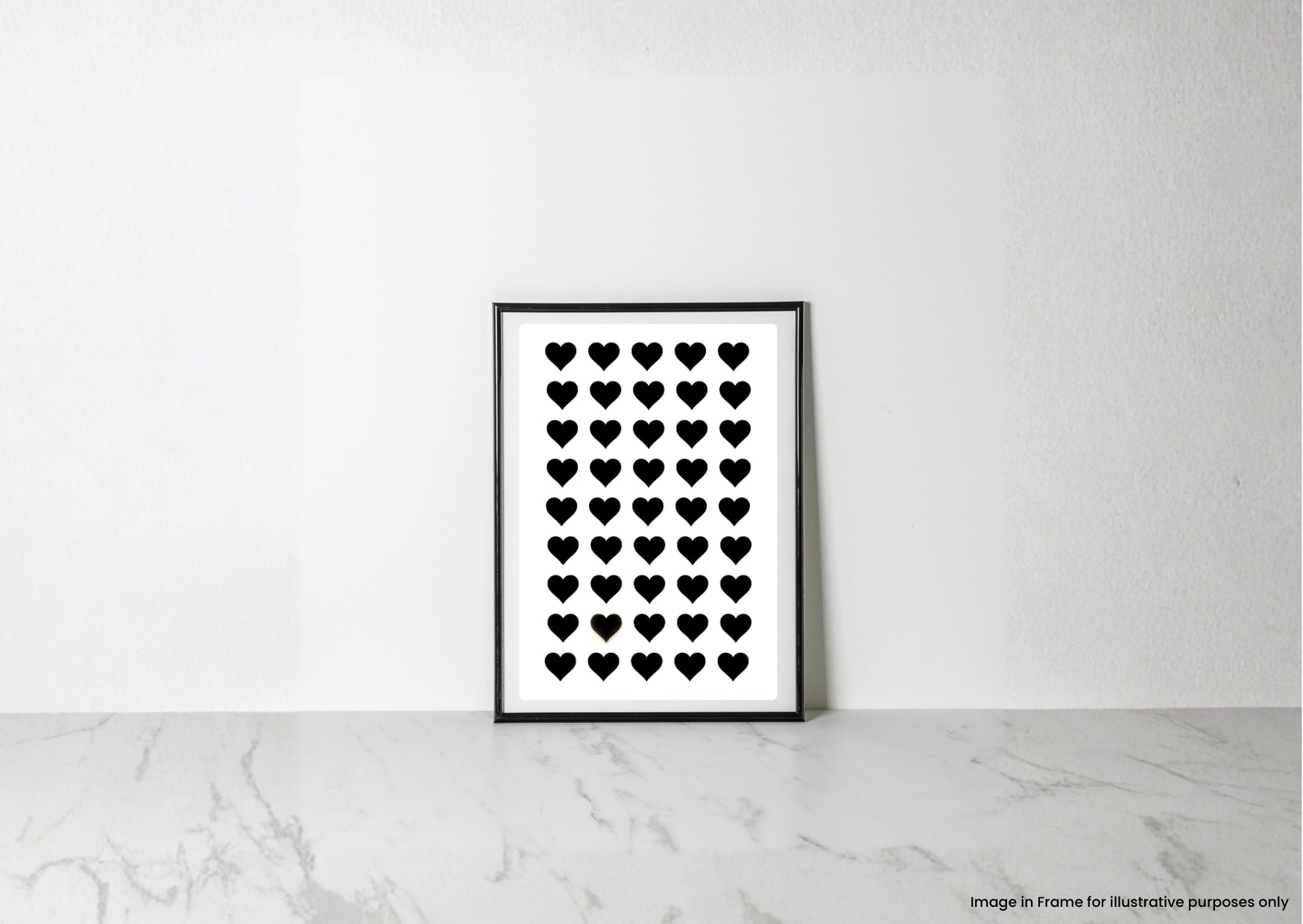 A minimalist black and white art print featuring a grid of small black hearts on a white background, displayed in a thin black frame leaning against a white wall on a light marble surface.