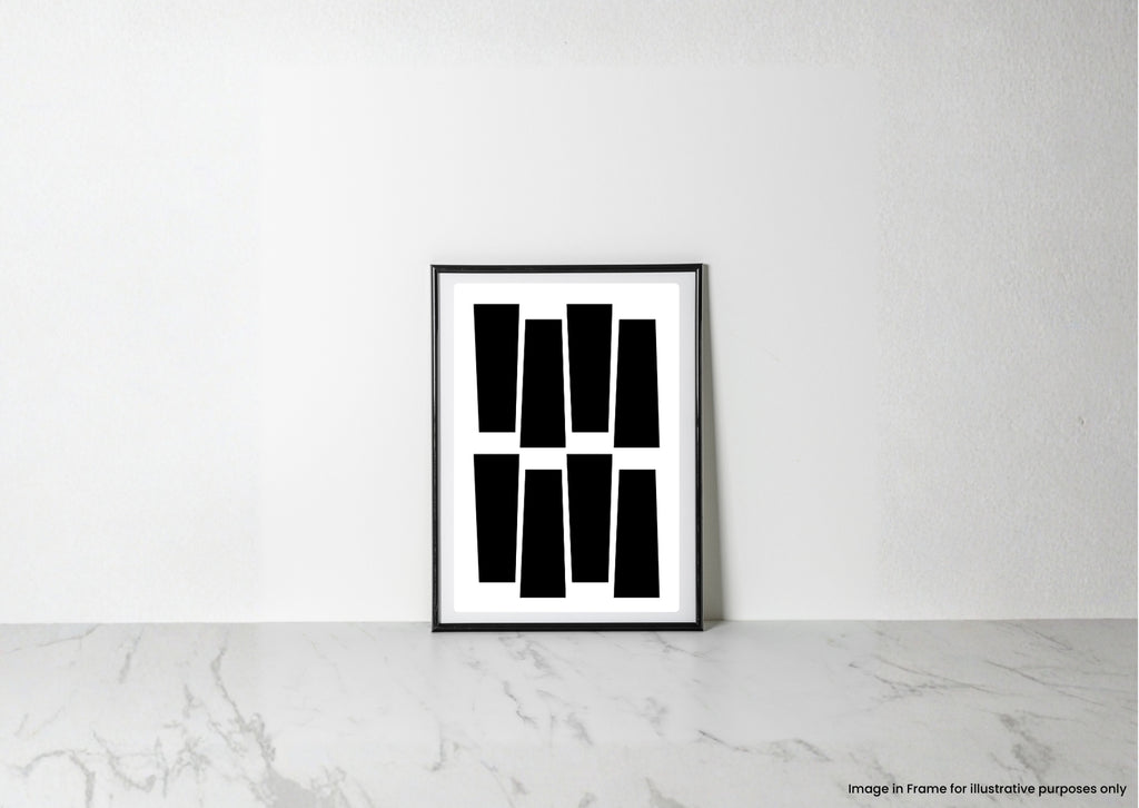 A minimalist black and white framed art print with geometric shapes, leaning against a white wall on a light marble surface.