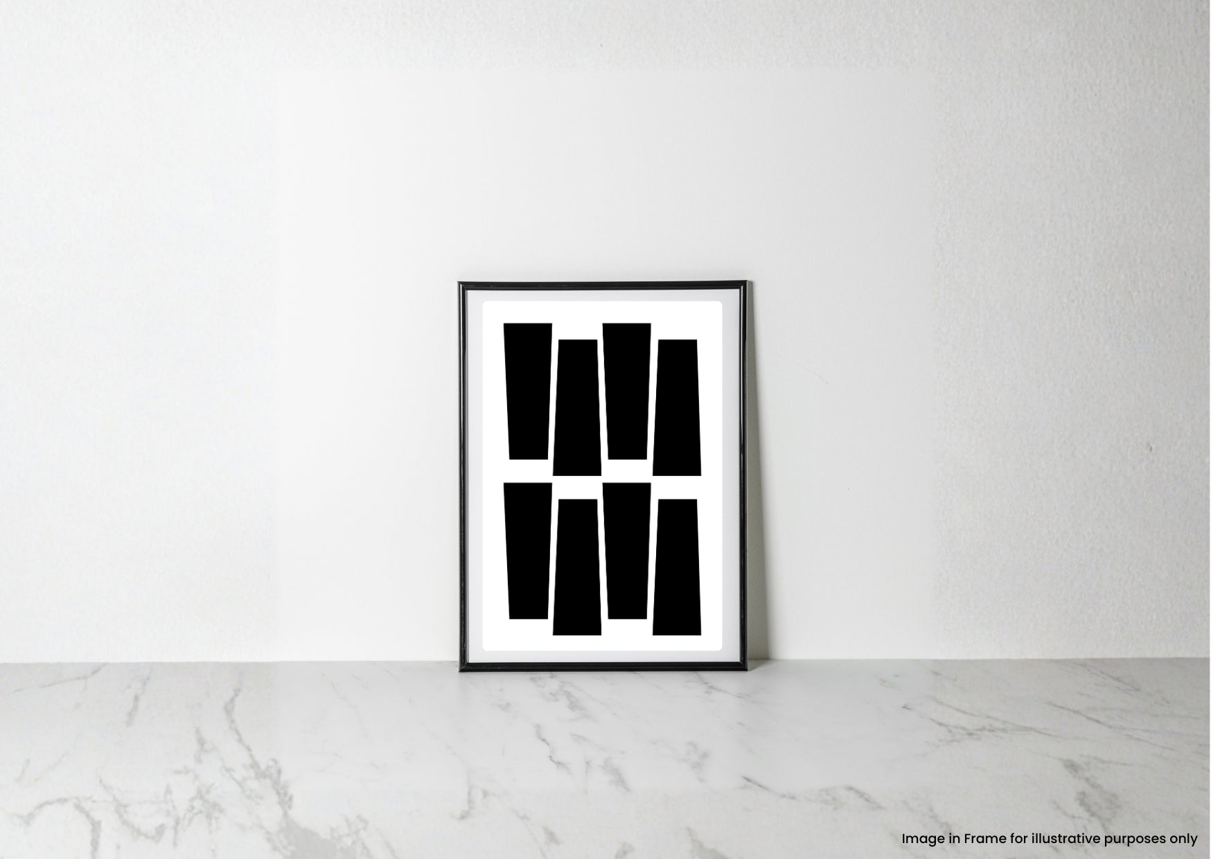 A minimalist black and white framed art print with geometric shapes, leaning against a white wall on a light marble surface.