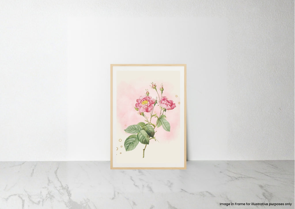A framed botanical art print featuring pink roses with green leaves on a soft pink and cream background, leaning against a white wall on a light marble surface.