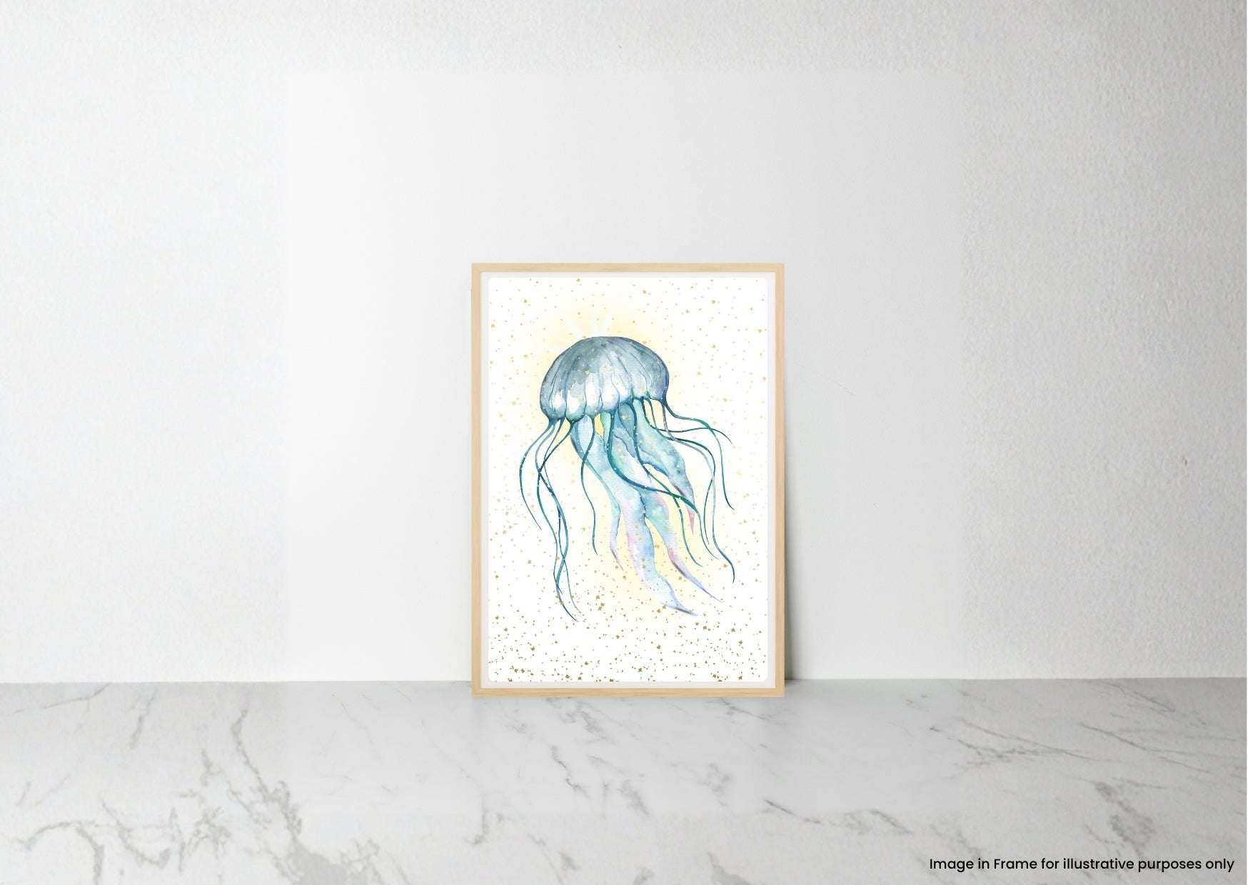 A vertical framed art print featuring a watercolor illustration of a blue and teal jellyfish on a white background with subtle gold speckles, leaning against a white wall on a light gray marble surface.