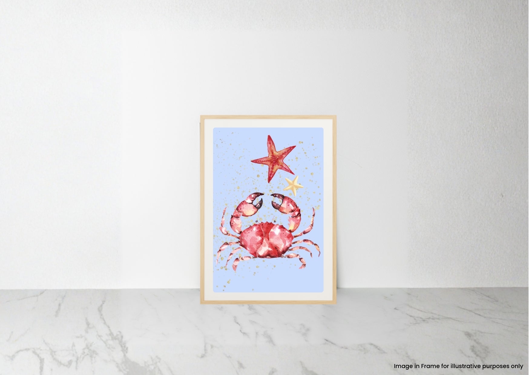 A framed art print featuring a watercolor-style red crab and red starfish on a light blue background, leaning against a white wall on a light marble surface.