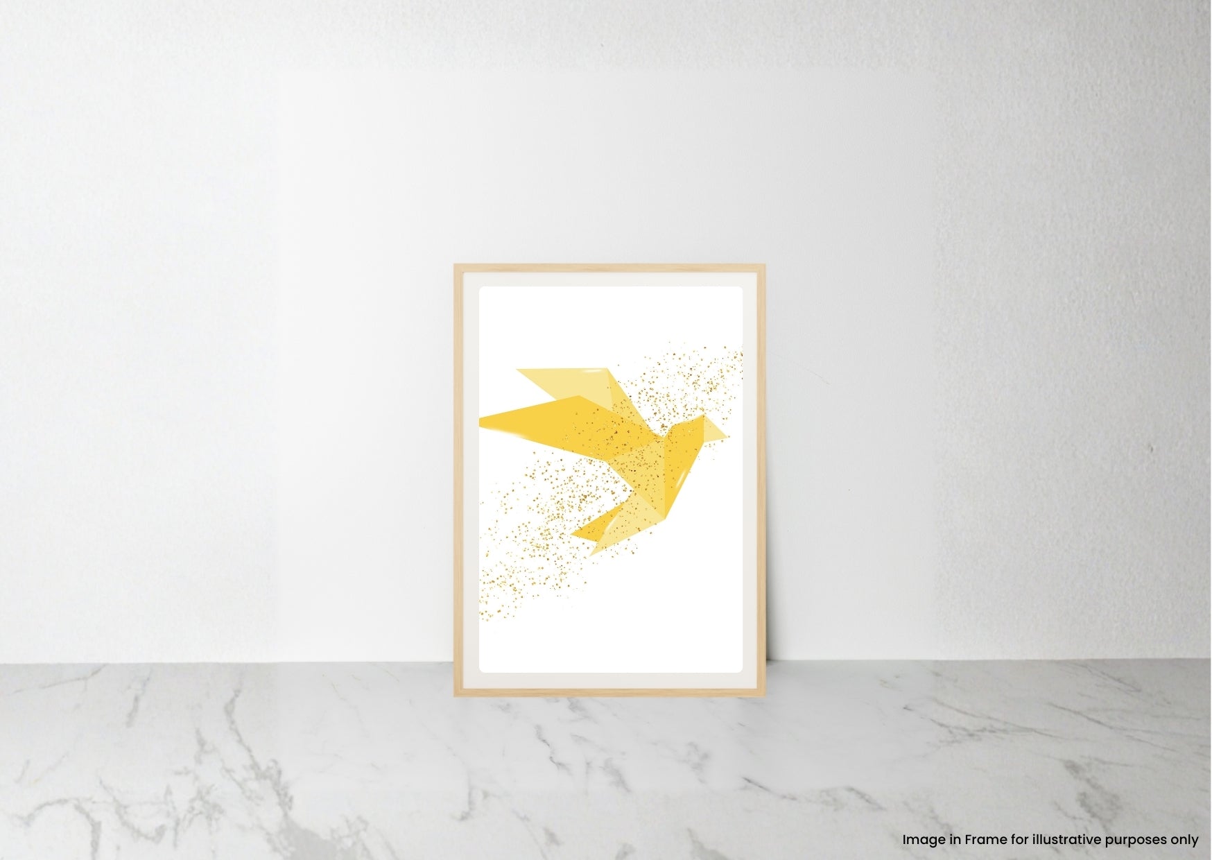 A framed art print featuring a minimalist yellow bird made of gold glitter-like speckles on a white background, leaning against a white wall on a light gray marble surface.