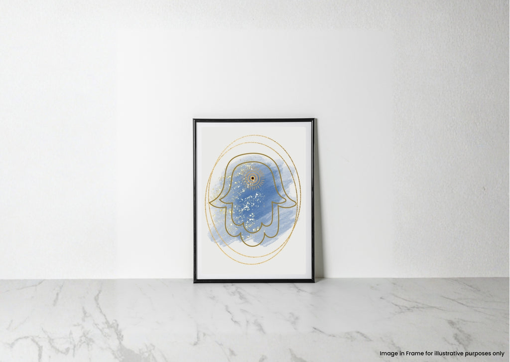 A framed abstract art print featuring a blue Hamsa hand with gold line details, leaning against a white wall on a light marble surface.