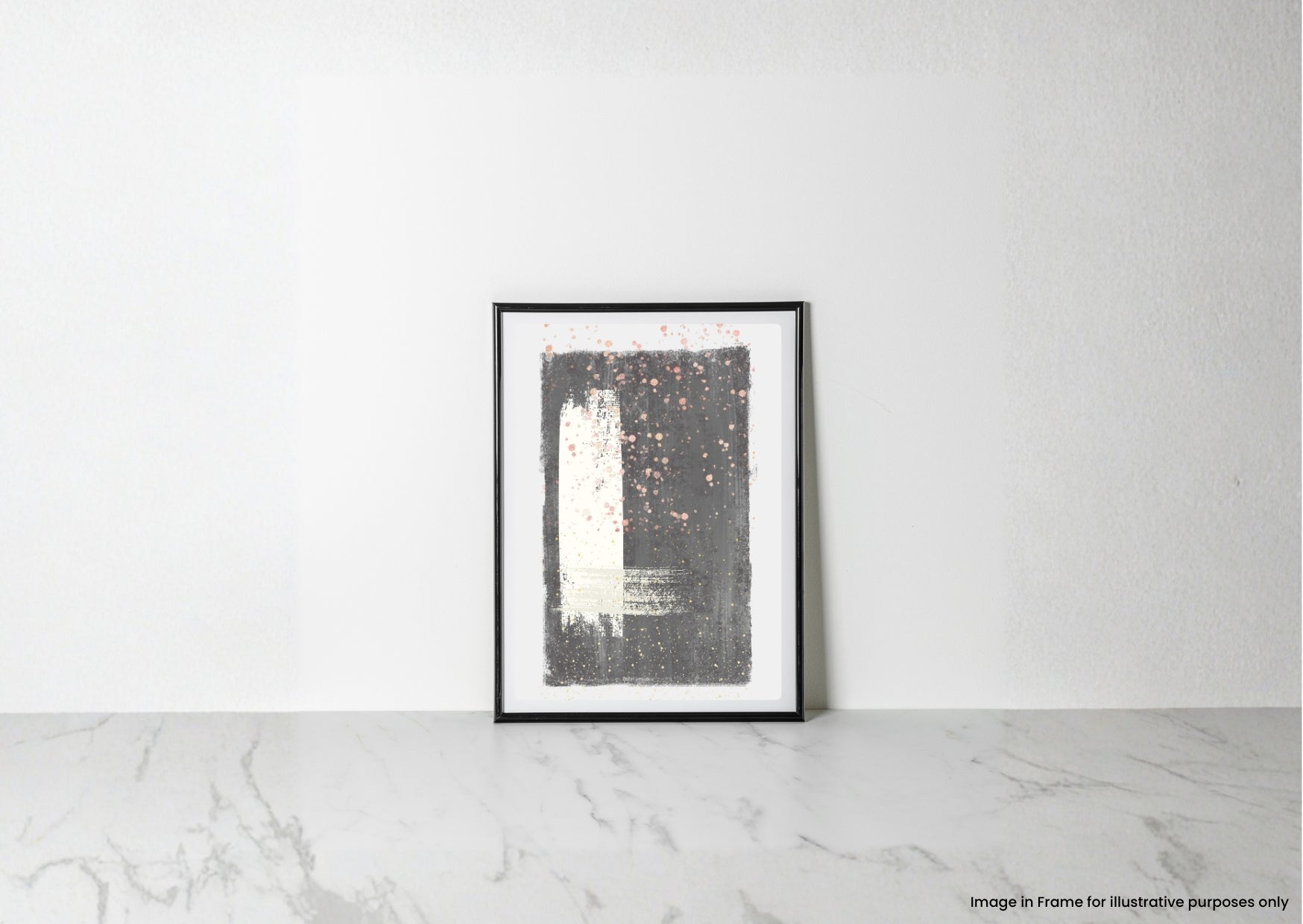 A framed abstract art print with a black and white design and small pink speckles, leaning against a white wall on a light marble surface.
