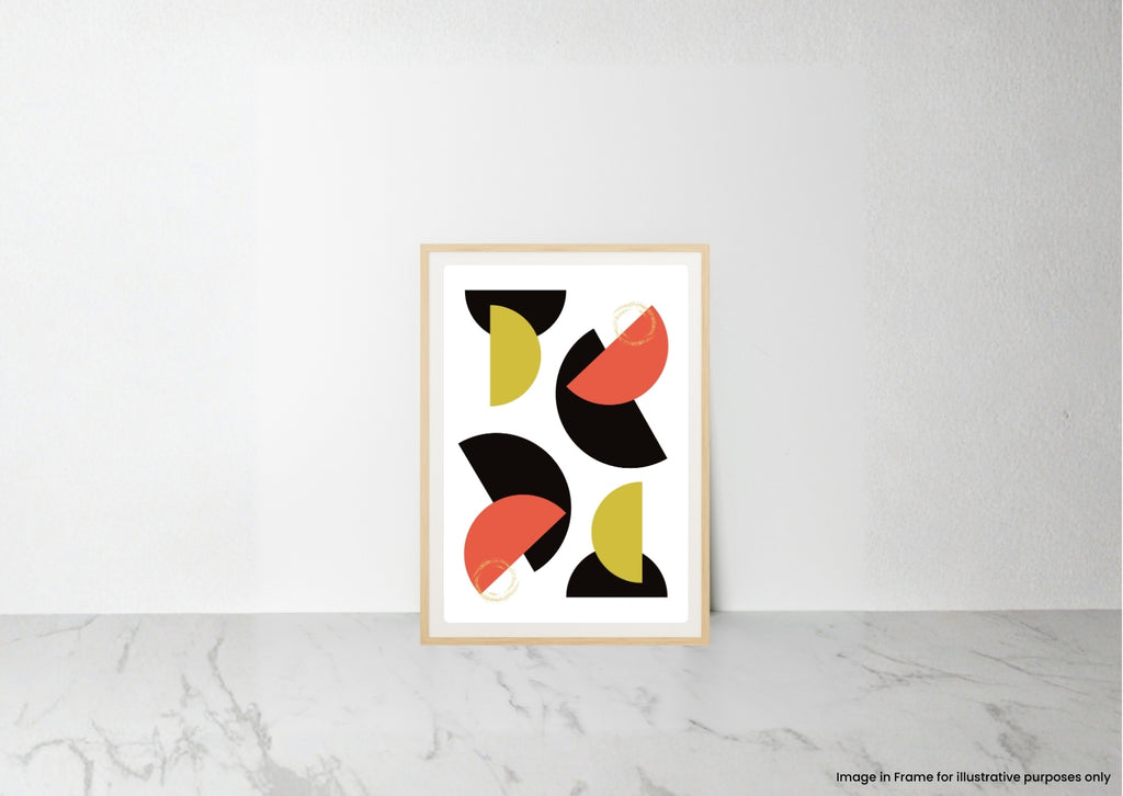 A framed abstract art print with geometric shapes in black, coral red, and olive green on a white background, leaning against a white wall on a light marble surface.