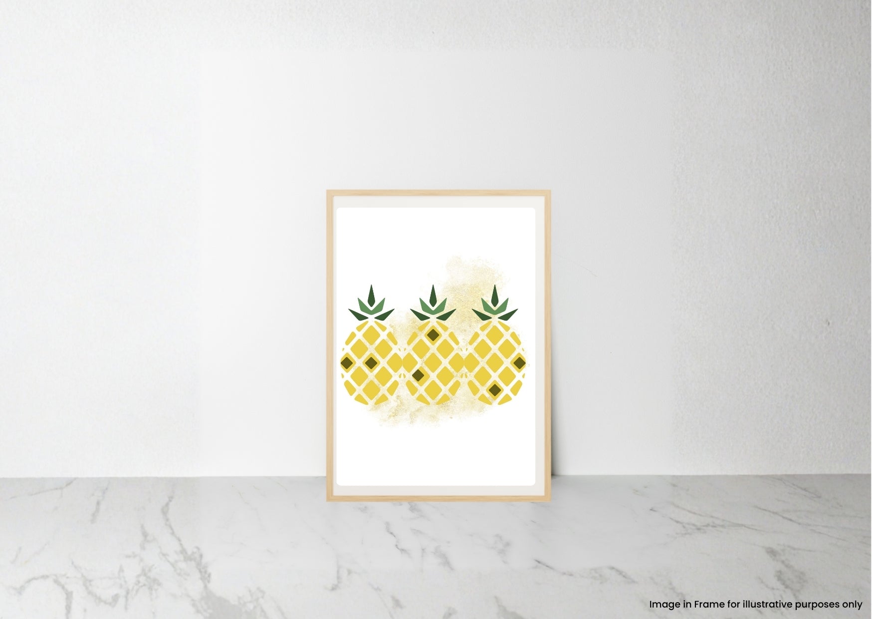 A framed art print featuring three yellow watercolor pineapples with green tops, displayed on a light gray marble surface against a white wall.
