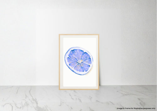A framed watercolor art print of a blue and purple lemon slice, displayed on a light marble surface against a white wall.