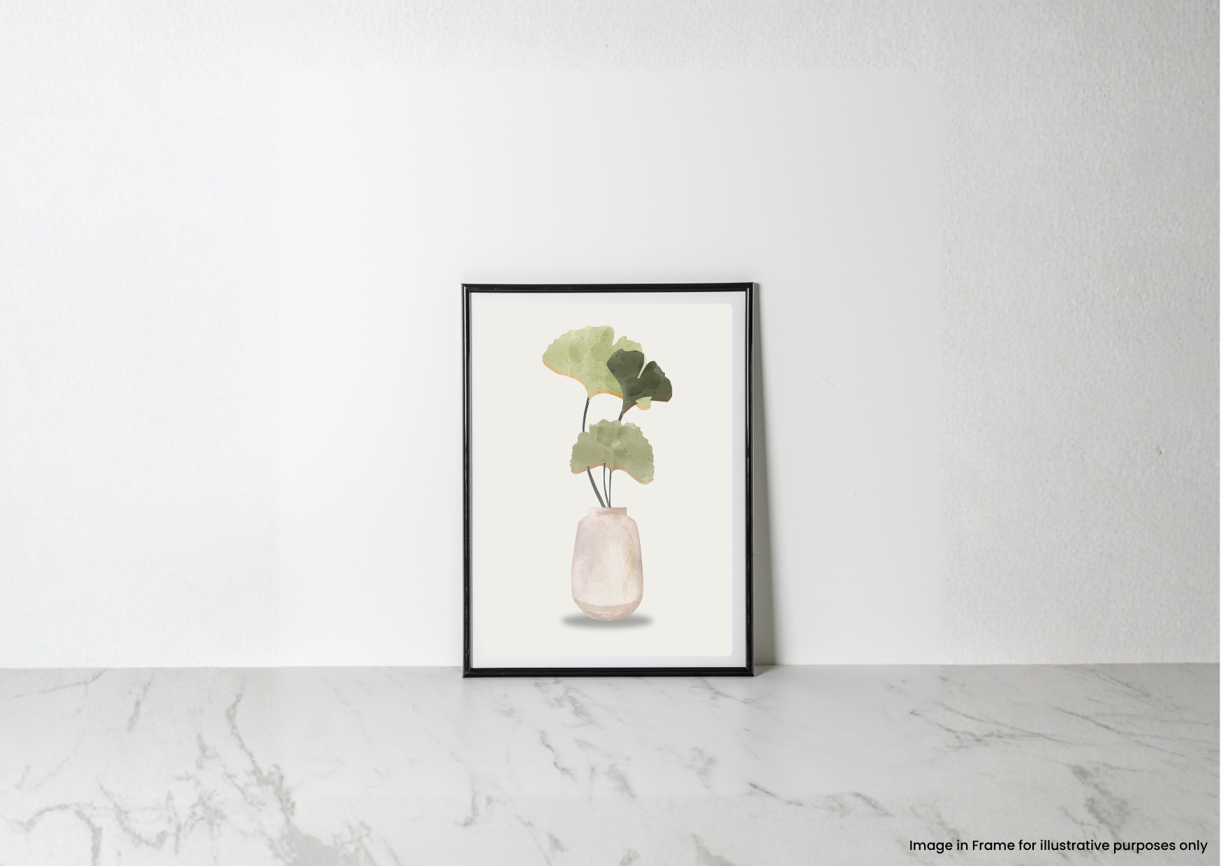 A framed botanical art print featuring green leaves in a pale pink vase, leaning against a white wall on a light marble surface.